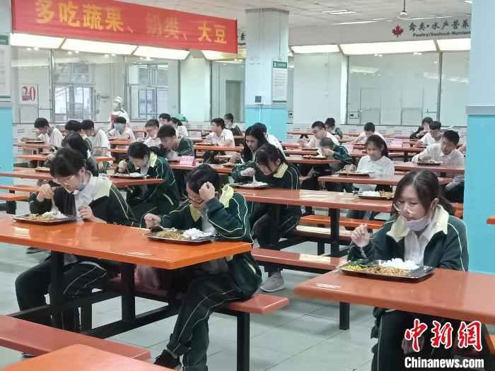 海南枫叶国际学校学生就餐相隔一米以上,实行专人专座,且只能单向就坐。 张茜翼 摄 海南高三、初三开学 单人单桌上课错时就餐